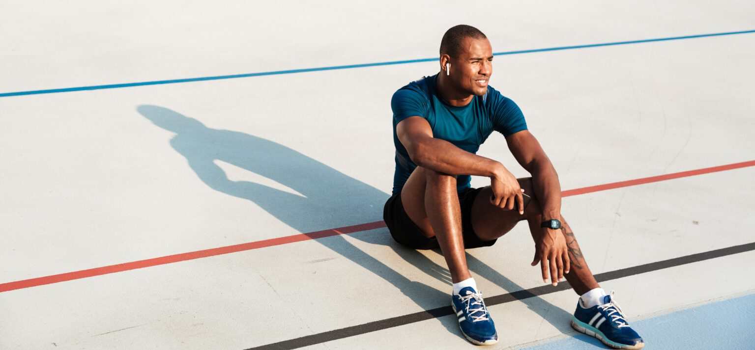 Sportif assis sur une piste d'athétisme